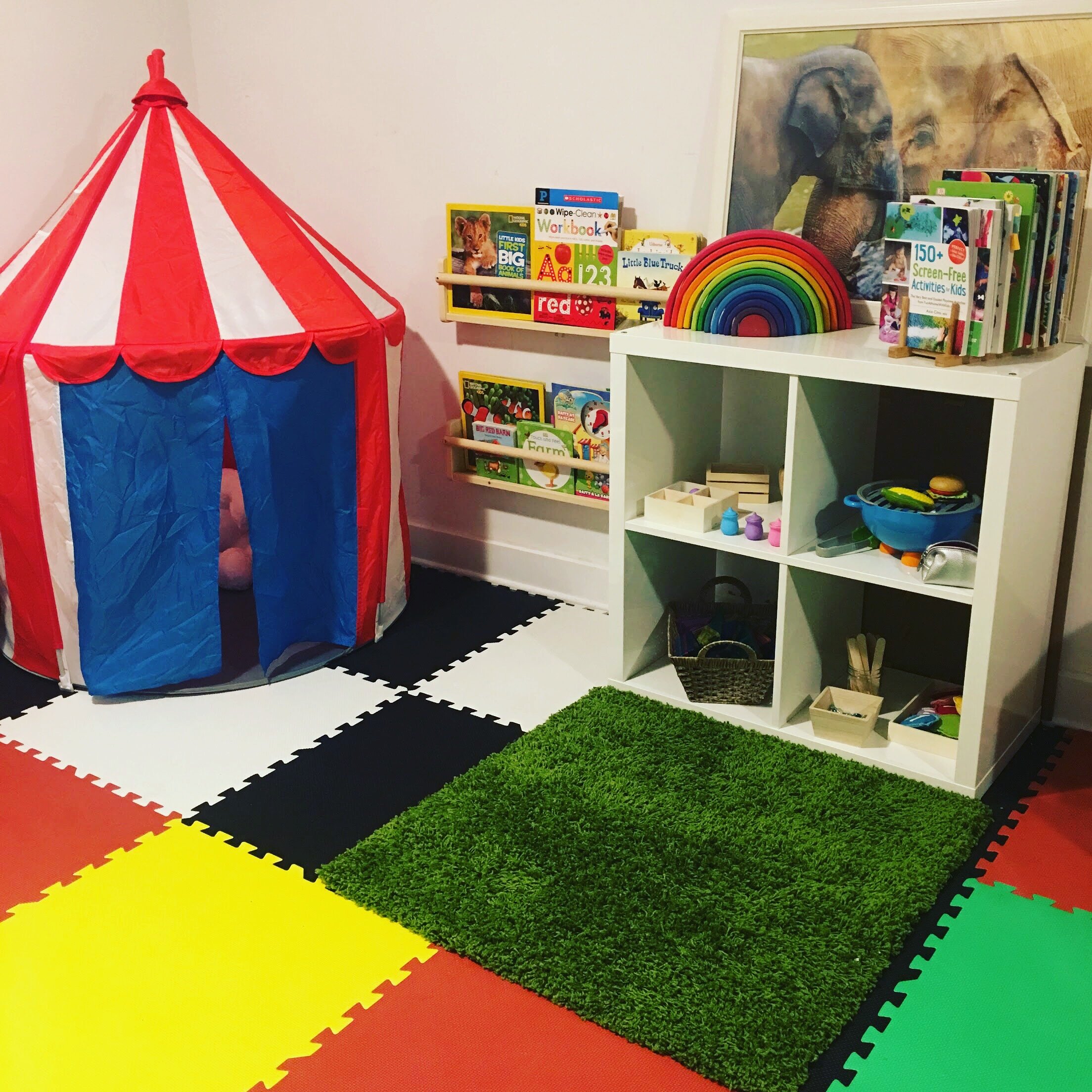 My playroom set up. A reading corner, IKEA KALLAX shelf with small invitations to play and to the right (not in picture) an arts corner.