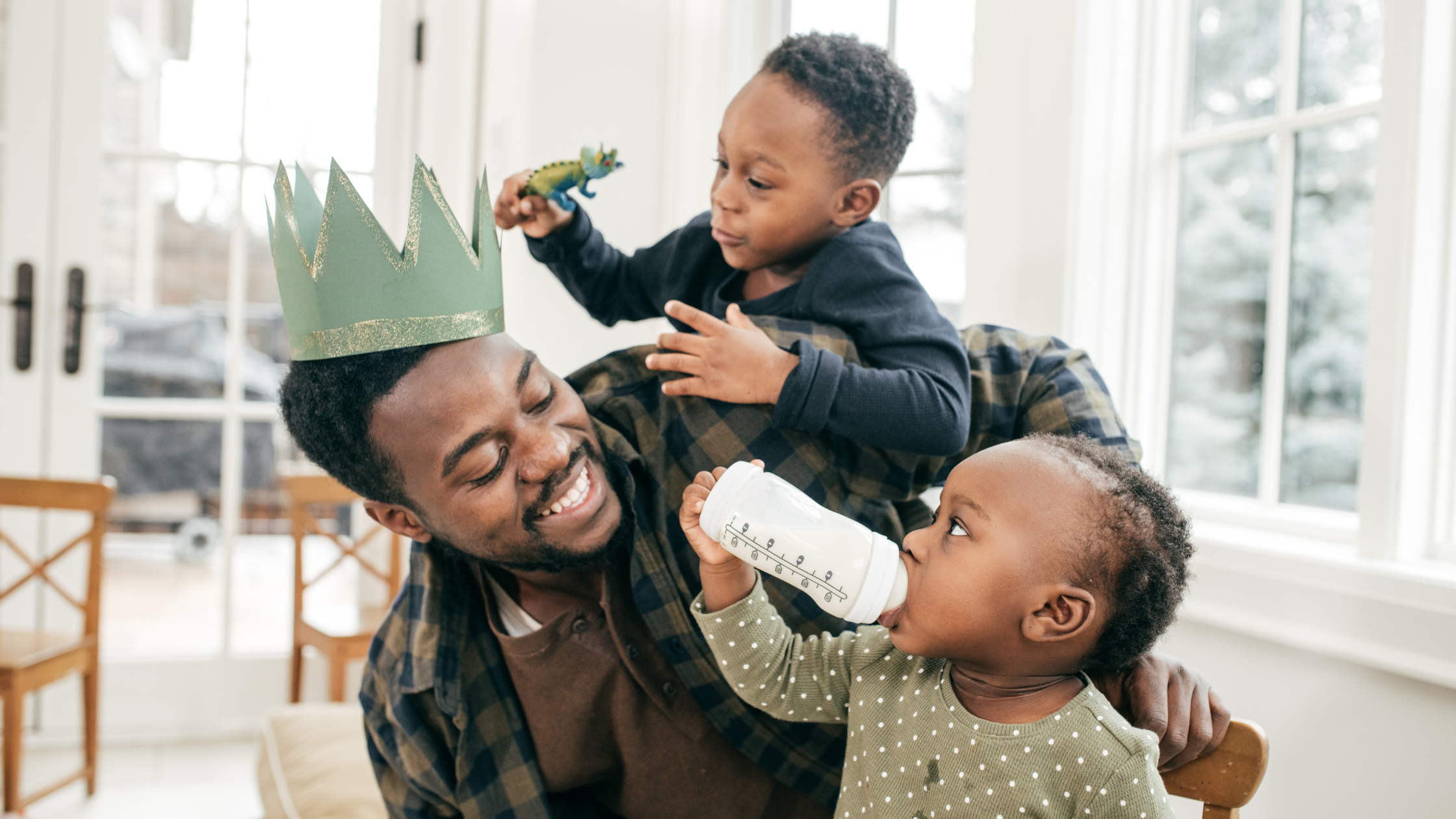 father of two young children laughs while playing with them