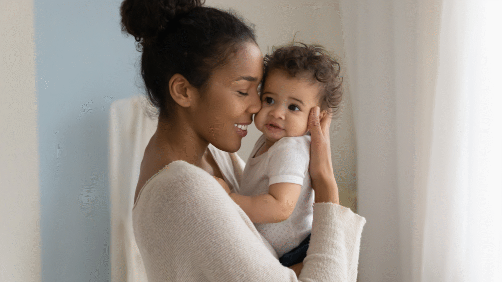 mother smiles while she holds her baby
