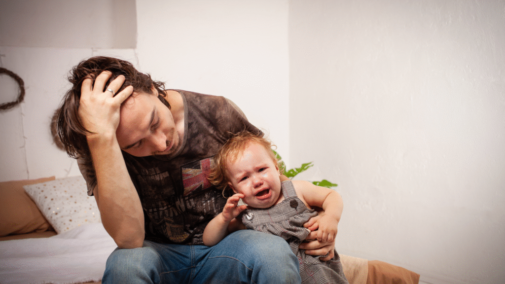 frustrated dad holding toddler throwing tantrums
